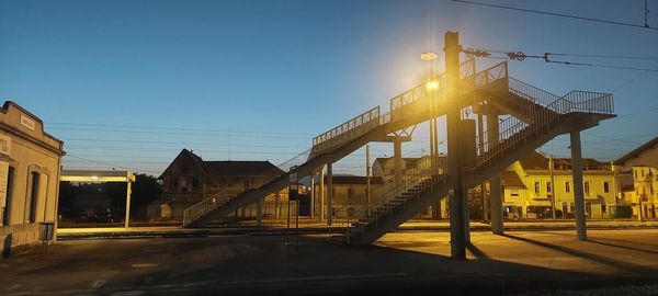 Street amidst buildings against clear sky during sunset