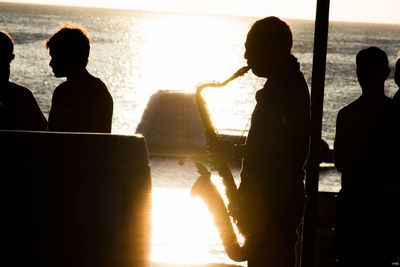 Silhouette of men sitting on airplane window