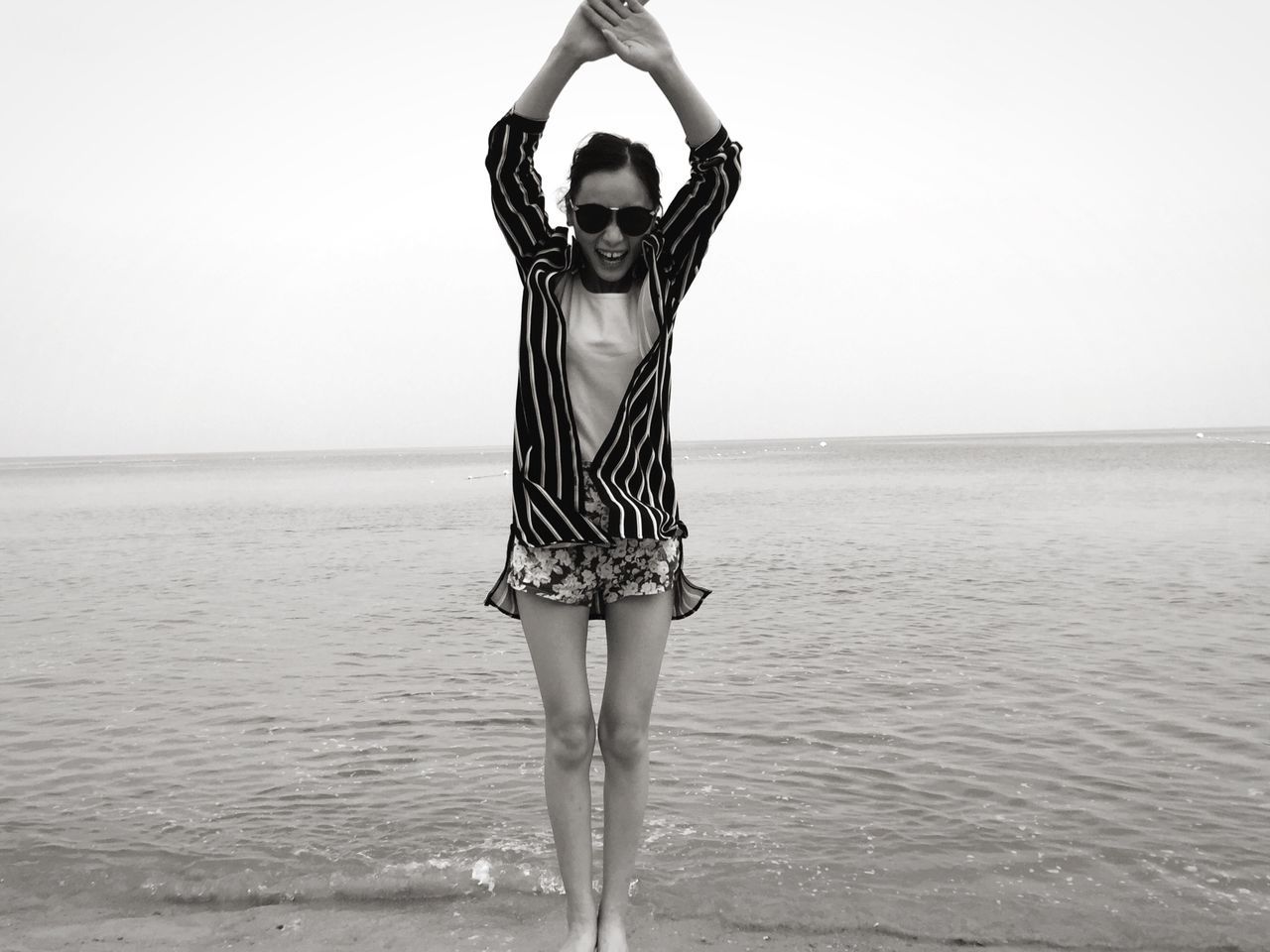 young adult, sea, standing, water, lifestyles, full length, young women, horizon over water, casual clothing, leisure activity, front view, clear sky, copy space, person, three quarter length, tranquility, sensuality