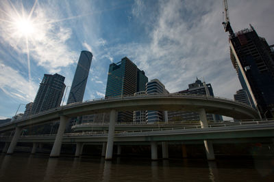 Low angle view of skyscrapers against cloudy sky