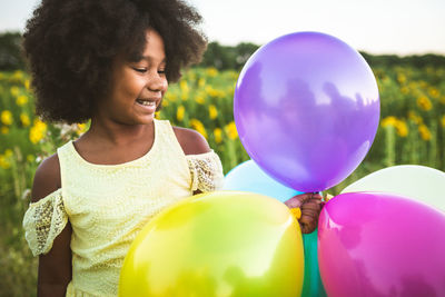 Close-up of smiling girl holding balloons