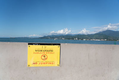 Information sign on beach against sky