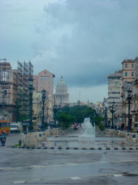 View of city street and buildings against sky