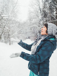 Side view of boy looking at snow covered land