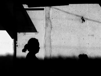 Silhouette man standing against wall