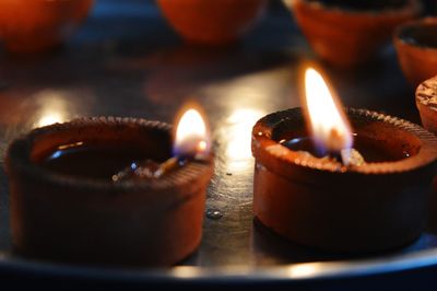 Close-up of illuminated oil lamps on table