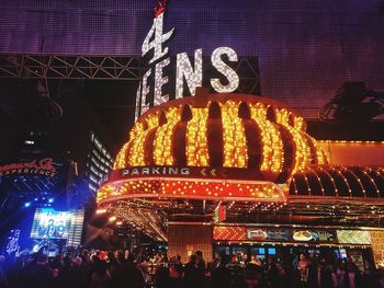 Group of people in front of illuminated building at night