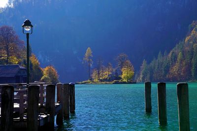 Wooden posts in lake against sky