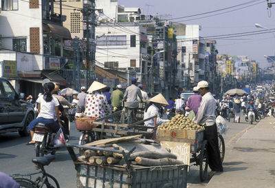 People on road against buildings in city