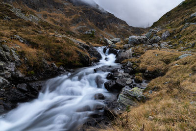 Scenic view of waterfall against sky