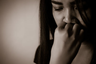 Close-up of thoughtful woman against wall