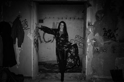 Portrait of young woman standing in abandoned room