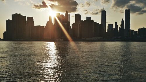Modern buildings in city against sky during sunset