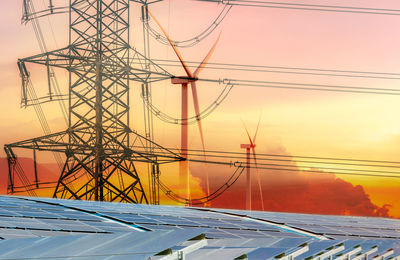 Low angle view of electricity pylon against sky during sunset