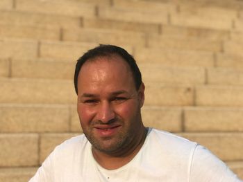 Close-up portrait of mid adult man standing against wall