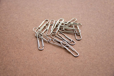 Close-up of paper clips on brown table