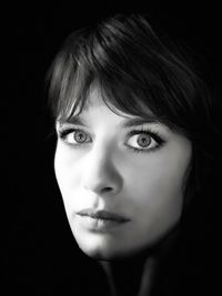 Portrait of young woman against black background