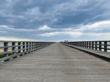 View of footbridge against cloudy sky