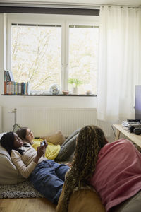 Multiracial teenage friends spending leisure time at home during weekend