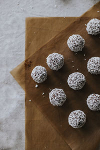 High angle view of coconut balls on wax paper