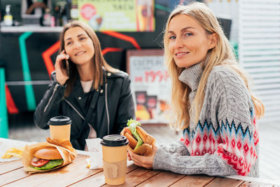 Portrait of smiling friends having food at restaurant