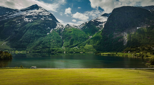 Scenic view of lake and snowcapped mountains against sky