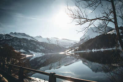 Scenic view of lake by snowcapped mountains against sky