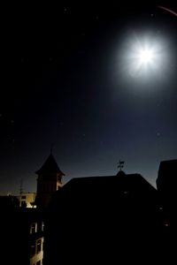 Low angle view of silhouette built structure against sky at night