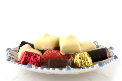 Close-up of chocolate cake in plate against white background