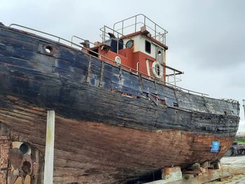 Low angle view of abandoned ship against sky