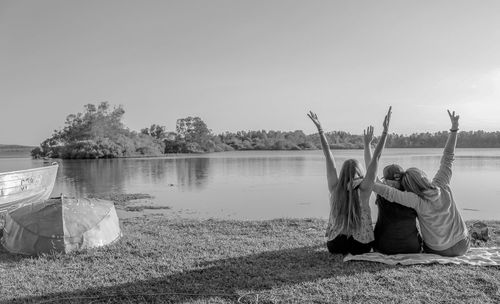 Woman with arms raised against sky