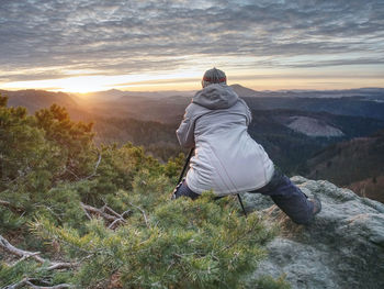 Photographer taking picture. woman artist photo enthusiast stay with camera above valley and works