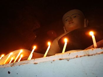 Close-up of lit candles in temple