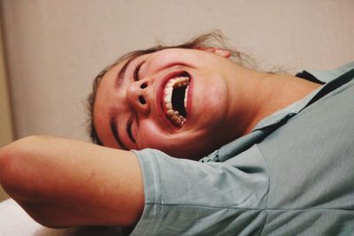 Close-up of happy girl lying at home