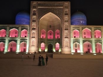 Group of people in front of illuminated building at night