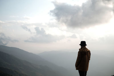 Rear view of man standing against mountain