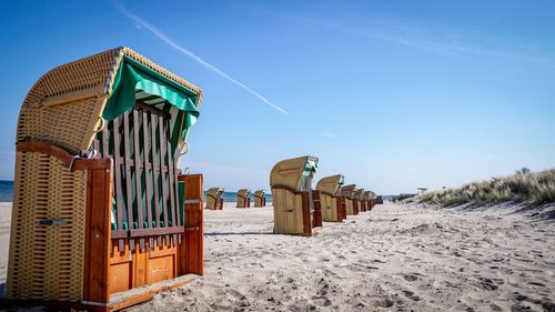 Hooded beach chairs against clear blue sky