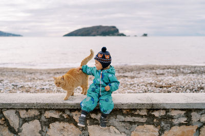 Rear view of woman with dog on footpath