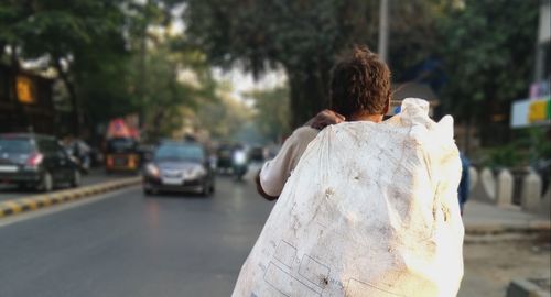 Rear view of woman standing on street in city