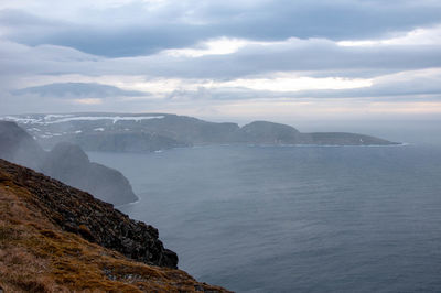 Scenic view of sea and mountains against sky