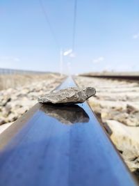 Close-up of stone on rock against sky