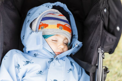 High angle view of cute girl wearing warm clothing while lying in baby stroller