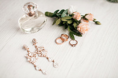 Wedding accessories for the preparation of the bride. gold earrings, perfume, boutonniere, rings