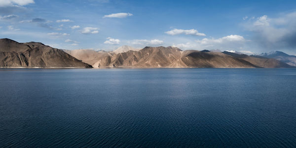 Scenic view of sea and mountains against sky