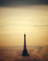 Tower in city against sky during sunset