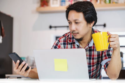 Young woman using mobile phone at home