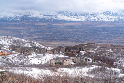 Aerial view of townscape and snowcapped mountain against sky