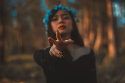 Portrait of beautiful woman gesturing in forest