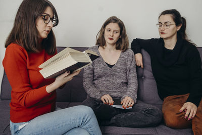 Young woman sitting on sofa at home