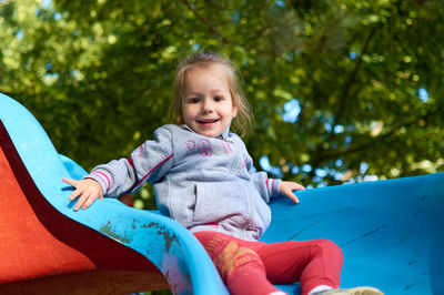 Portrait of a smiling girl sitting outdoors